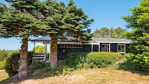 A house with a covered porch, a small deck, and a well-maintained garden. - 6 Person Holiday Home in Ebeltoft-by Traum (Ebeltoft)