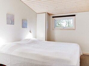 A bedroom with a bed, a window, and two wall-mounted artworks. - 4 Star Holiday Home in Saeby (Sæby)
