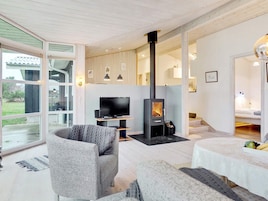 Una sala de estar moderna con chimenea, televisor y comedor.