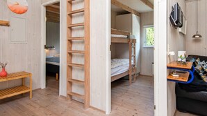 A compact room with a bunk bed, a wooden ladder, a small table with a lamp, and a TV mounted on the wall. - 8 Person Holiday Home in Ebeltoft (Ebeltoft)