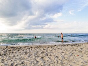 A beach with sand, waves, and people. - 4 Person Holiday Home in Frederiksvaerk (Frederiksvaerk)