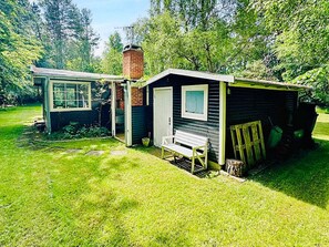 A small, single-story cabin with a front porch, a door, and a window. - 4 Person Holiday Home in Frederiksvaerk (Frederiksvaerk)