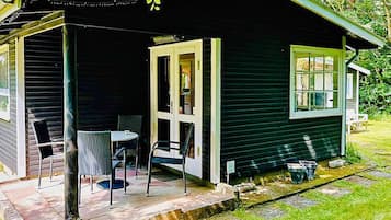 A small house with a porch, a table, and chairs.