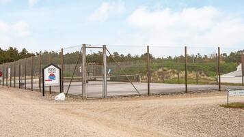 A fenced area with a sign indicating 'RIM ROMO' and 'FORSAMLINGSHUS'.