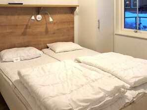 A bed with white bedding and a wooden headboard. - 4 Star Holiday Home in Salen (Salen)
