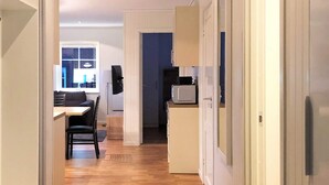 A narrow hallway with a wooden floor leading to a dining area with a table and chairs. - 4 Star Holiday Home in Salen (Salen)