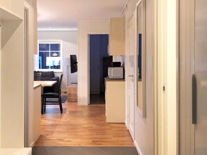 A narrow hallway with a wooden floor leading to a dining area with a table and chairs. - 4 Star Holiday Home in Salen (Salen)