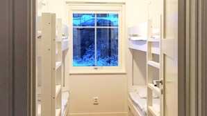 A narrow hallway with wooden flooring, white built-in shelving units on both sides, and a window at the end. - 4 Star Holiday Home in Salen (Salen)