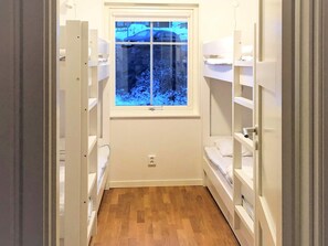 A narrow hallway with wooden flooring, white built-in shelving units on both sides, and a window at the end. - 4 Star Holiday Home in Salen (Salen)
