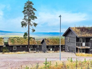 A row of cabins with a grassy roof, a tall tree, and a clear view of the landscape. - 4 Star Holiday Home in Salen (Salen)