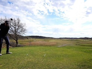 A golf course with a clear sky and a single golfer in the foreground. - 4 Star Holiday Home in Salen (Salen)