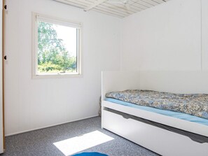 A bedroom with a single bed, a window, and a ceiling fan.