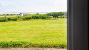 Een uitzicht op een grasveld met een wit gebouw in de verte.