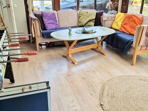 Ett rum med en soffa, ett runt bord och en stol.