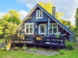 A house with a dark exterior, white trim, and a covered porch with outdoor furniture. - 5 Person Holiday Home in Odder (Odder)