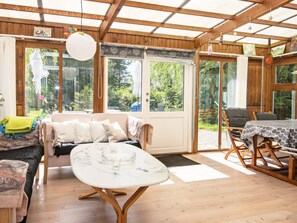 A sunlit room with a sofa, a table, and a dining area. - 5 Person Holiday Home in Odder (Odder)