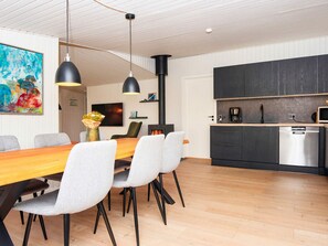 Une cuisine moderne avec des meubles de rangement de couleur sombre, un lave-vaisselle encastré et un four à micro-ondes.