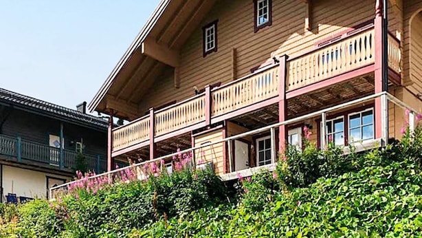Ein zweistöckiges Holzhaus mit Balkon und einer Treppe, die dorthin führt.