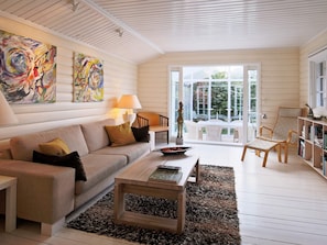 A living room with a sofa, coffee table, and artwork on the wall.