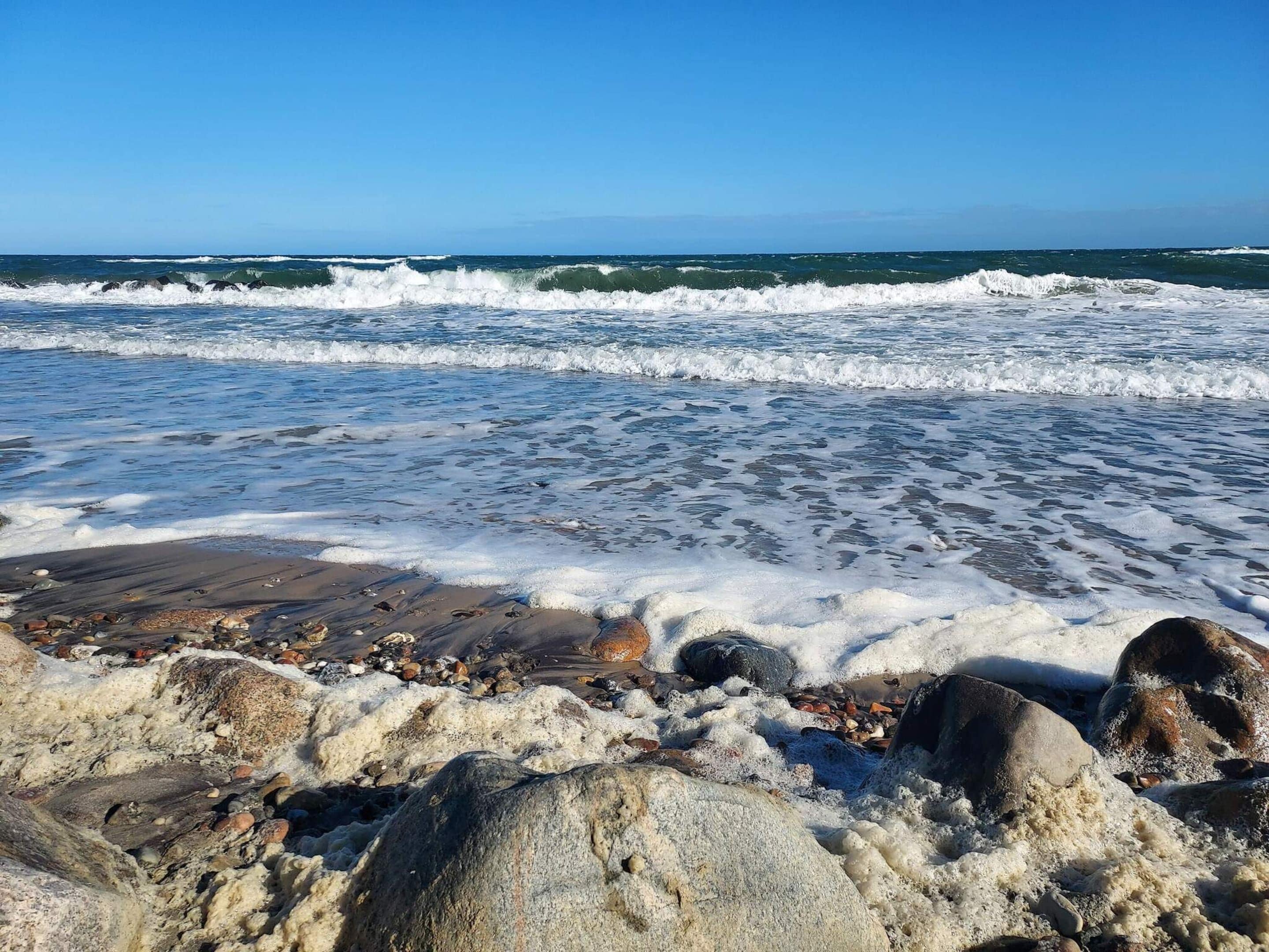 A rocky beach with waves crashing onto the shore.