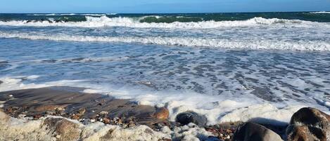 A rocky beach with waves crashing onto the shore.