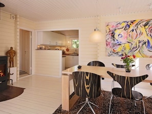 A modern interior with a dining area, a fireplace, and a vibrant abstract painting.