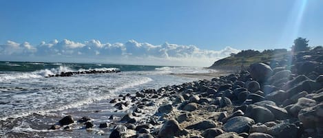 A rocky beach with waves crashing onto the shore.