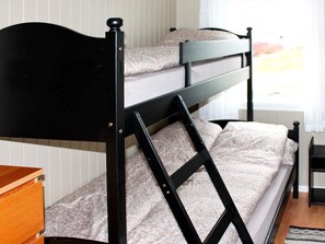 A bunk bed with a wooden headboard and a small wooden dresser beside it. - 6 Person Holiday Home in Averoy (Averoy)
