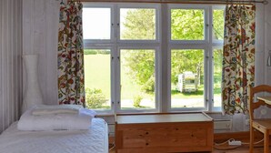 A bedroom with a large window, a bed, a wooden bench, and a chair. - 7 Person Holiday Home in Jarbo-by Traum (Jarbo)