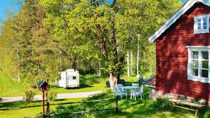 A red cabin with a white window, surrounded by a grassy area with a picnic table and chairs. - 7 Person Holiday Home in Jarbo-by Traum (Jarbo)