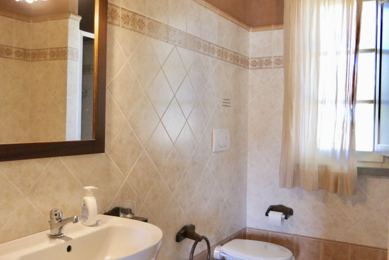 A bathroom with a sink, toilet, and mirror.