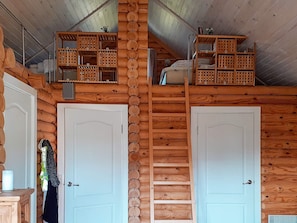 A cabin interior with two white doors, wooden shelves, and a ladder. - 6 Person Holiday Home in Hovborg (Hovborg)