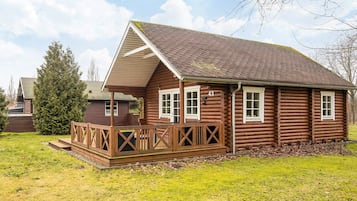 A log cabin with a wooden deck, a pitched roof, and a number '43' on the side.