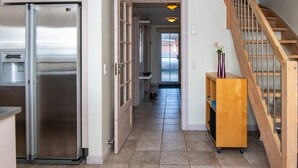 Eine moderne Küche mit einem Edelstahl-Kühlschrank, einem Holzschrank und einem integrierten Wasserspender.