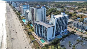 A coastal hotel with multiple high-rise buildings, a beach, and a parking area. - NEW! 10th Floor! Tip-Sea Turtle, Beach View! (Myrtle Beach)