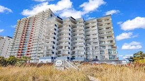A multi-story hotel with balconies, a beach path, and a clear sky. - NEW! 10th Floor! Tip-Sea Turtle, Beach View! (Myrtle Beach)