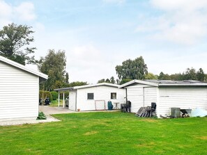 Une rangée de maisons mobiles blanches, avec une pelouse devant.