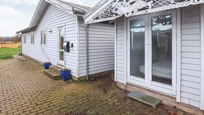 A white house with a decorative front porch and a mailbox. - 4 Star Holiday Home in Rodvig Stevns (Rodvig Stevns)