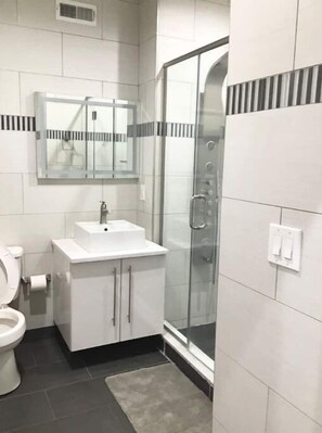 Douche, baignoire à remous, séchoir à cheveux, serviettes fournies