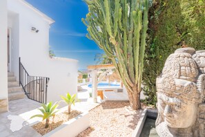 A white building with a staircase, a cactus, a stone sculpture, and a pool area. - CostaBlancaDreams - Casa Juleo in Benissa (Benissa)