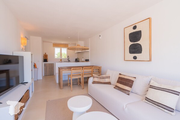 A modern living room with a sofa, a TV, and a dining area with chairs and a table. - CostaBlancaDreams - Casa Juleo in Benissa (Benissa)