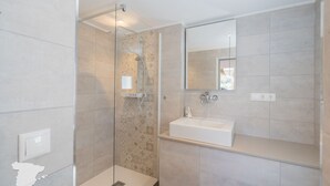 A modern bathroom with a glass-enclosed shower, a white sink, and a large mirror. - CostaBlancaDreams - Casa Juleo in Benissa (Benissa)