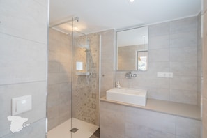 A modern bathroom with a glass-enclosed shower, a white sink, and a large mirror. - CostaBlancaDreams - Casa Juleo in Benissa (Benissa)