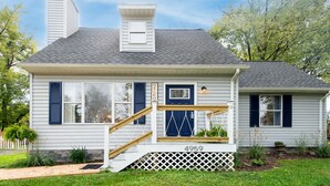 Une maison de plain-pied avec un porche à l’avant, un petit escalier et une boîte aux lettres.