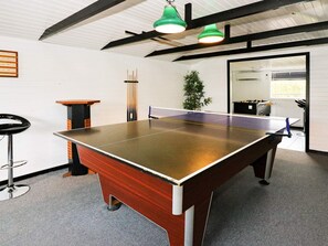 A ping pong table in a room with a high ceiling, a bar stool, a plant, and a table tennis table. - 4 Star Holiday Home in Hadsund (Hadsund)
