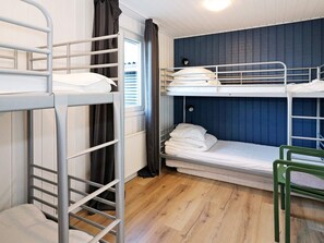A bunk bed room with a window, curtains, and a green chair. - 4 Star Holiday Home in Hadsund (Hadsund)