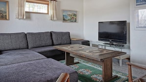 A living room with a sectional sofa, a television, a coffee table, and a patterned rug. - 8 Person Holiday Home in Hasle (Hasle)