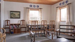 A dining area with wooden furniture, a bookshelf, and a painting on the wall. - 8 Person Holiday Home in Hasle (Hasle)