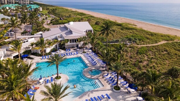 Ein Resort mit großzügigem Poolbereich, Zugang zum Strand und Blick auf den Ozean.