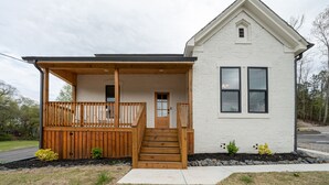 A single-story house with a wooden porch and a small front yard.